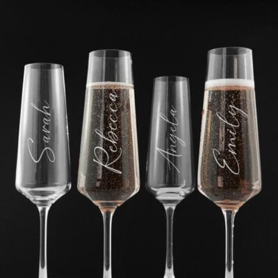 Vier gepersonaliseerde champagneglazen met verschillende namen voor bruidsmeisjes
