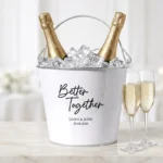 Wit Metalen Feestkoeler met zwarte opdruk BetterTogether, namen en datum gevuld met champagne en ijs.