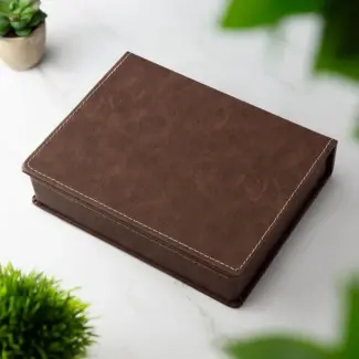Luxe bruine geschenkverpakking voor een getuige heupfles cadeau set, gesloten liggend op een marmeren tafel.