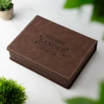 De gesloten, luxe bruine geschenkdoos van de getuige heupfles set, met een gepersonaliseerde gravure op de deksel