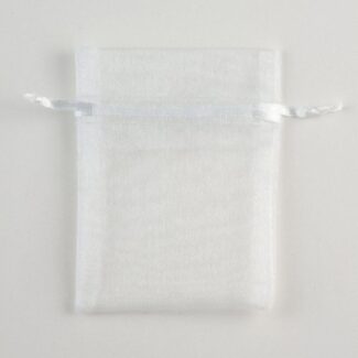 Wit, doorschijnend organza zakje met een wit trekkoord, plat liggend op een lichte ondergrond.