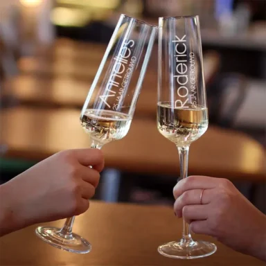 Elegante champagneglazen gegraveerd met de namen van het paar en '[X jaar] Getrouwd'