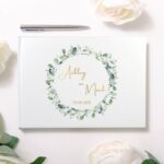 Wit hardcover gastenboek met goudkleurige personalisatie en delicate eucalyptus illustraties