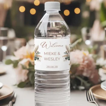 Close-up van waterfles etiket met zacht pampasgras design en Welcome tekst in blush tinten uit de Boho Blush Collectie