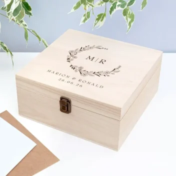 Houten bruiloft bewaarbox met botanische krans gegraveerd met initialen M en R namen Marion en Ronald en trouwdatum
