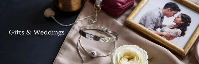 Elegante flatlay met originele cadeaus voor vrouwen, waaronder gepersonaliseerde armband, geurkaars en make-up tasje in bordeauxrood en taupe – Gifts & Weddings