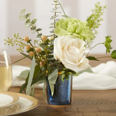 Navy mercury glas theelichthouder met gouden rand gebruikt als mini vaasje met delicate witte bloemen