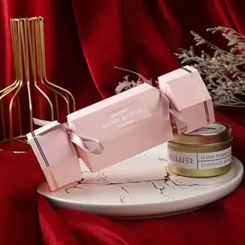 Elegante roze toffee-vormige geschenkdoosjes met gouden randafwerking en wit lint. Perfect voor bruiloften en feestelijke gelegenheden. Afmeting 18x5