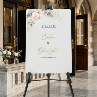 Welkomstbord bruiloft met blush rozen en eucalyptus, gepersonaliseerd met namen en datum op schildersezel bij stadhuis entree