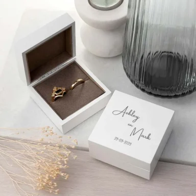 Wit houten ringdoosje met elegante script lettertype gravering van namen en trouwdatum