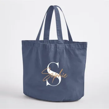 Close-up van modern script personalisatie op vintage denim strandtas