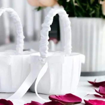 Klassiek wit satijnen strooimandje met grote strik en parelaccent voor de huwelijksceremonie.