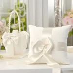 Luxe ivoorkleurige bruiloft ceremonieset bestaande uit een satijnen ringkussen en een strooimandje met parels.