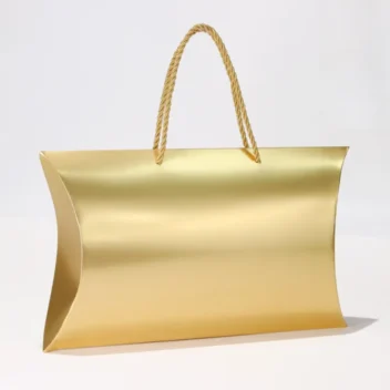 Grote gouden pillow box cadeautas met handvatten voor luxe geschenken.