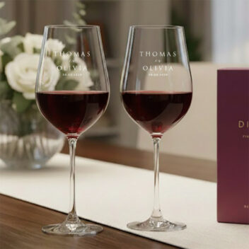 Set van twee gepersonaliseerde kristallen rode wijnglazen met wit-matte gravure als luxe cadeau voor het bruidspaar.