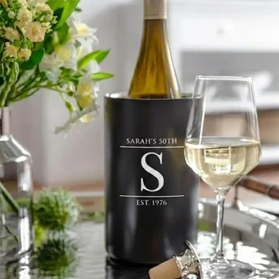 Modern matzwarte wijnkoeler met Sarah 50 jaar gravure en eigen naam op een gedekte tafel