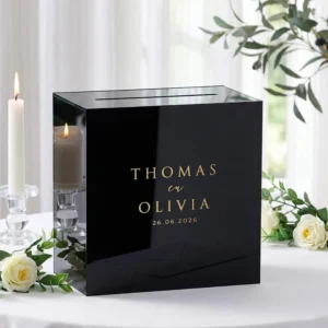 Zwarte acryl enveloppendoos met goud spiegel branding op een gedekte cadeautafel.