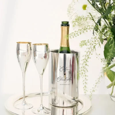 Zilveren wijnkoeler gepersonaliseerd met namen en trouwdatum voor bruidspaar, met twee champagneglazen