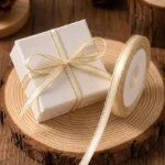 Luxe crème lint van 1 cm breed met een verfijnde gouden rand voor een volle strik om cadeaudoosjes.