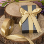 Luxe gouden satijn lint van 2,5 cm breed op een rol van 25 meter voor strikken om cadeaudoosjes