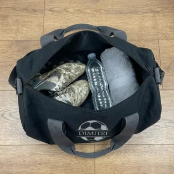Gepersonaliseerde sporttas met naam voetbal open met schoenen bidon en handdoek erin 20 liter ruimte