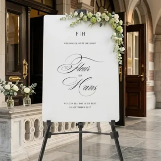 Florence Monogram Welkomstbord in wit acryl met zwarte scripttypografie, monogram initialen en namen op schildersezel bij stadhuisentree