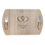 Houten borrelplank met gravure van twee verstrengelde harten en tekst "25 jaar liefde & geluk – De familie Jansen", met twee magnetische messen aan de zijkant