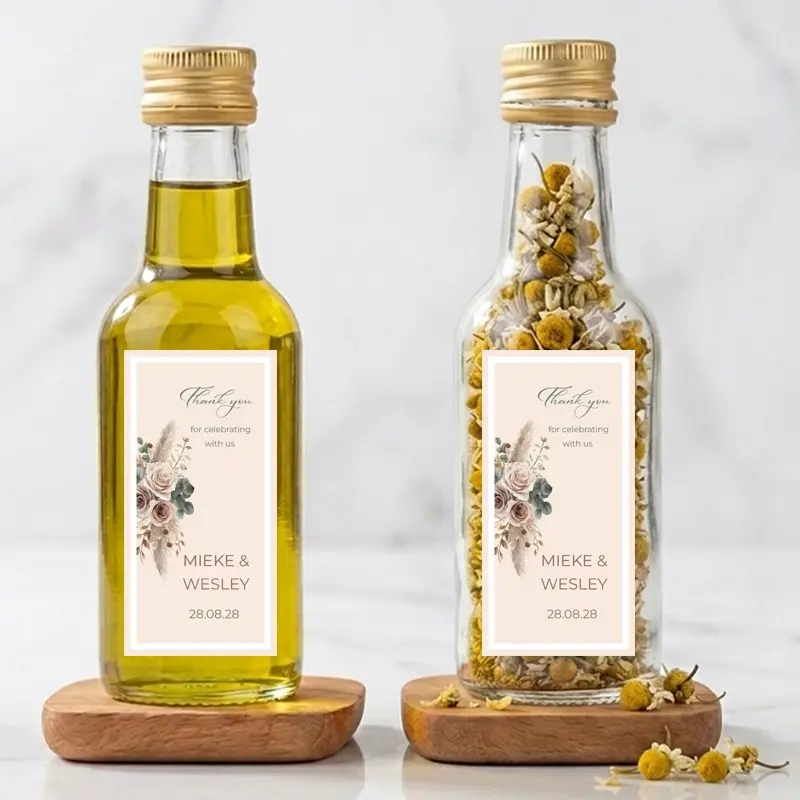 Rosie mini flesje bedankje met Boho Blush etiket Twee kleine flesjes met Boho Blush etiket, één met olijfolie en de ander met gedroogde kamille, beide voorzien van een bedanklabel voor bedankjes bruiloft.